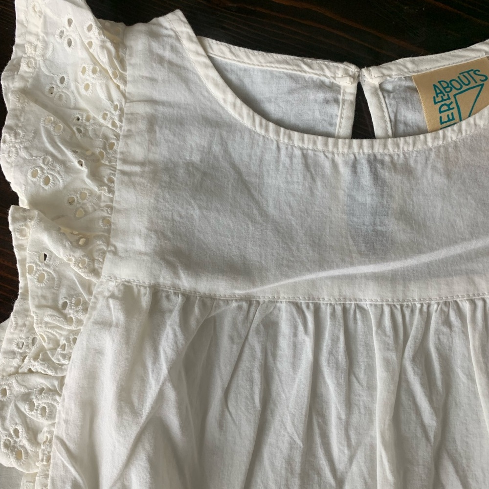 Girls off-white top with eyelet sleeve.